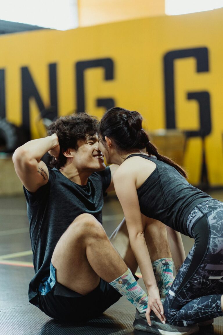 Happy couple exercises together in gym, fostering motivation and closeness.